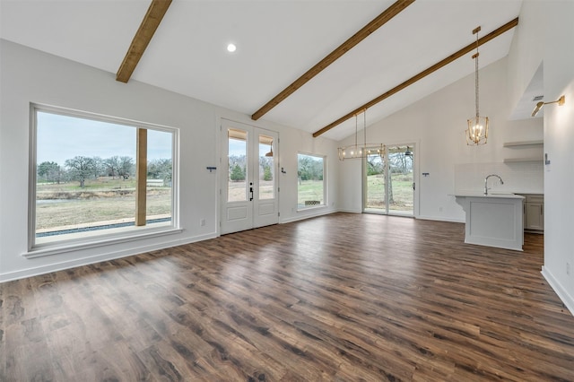 unfurnished living room with a sink, baseboards, french doors, beamed ceiling, and dark wood finished floors