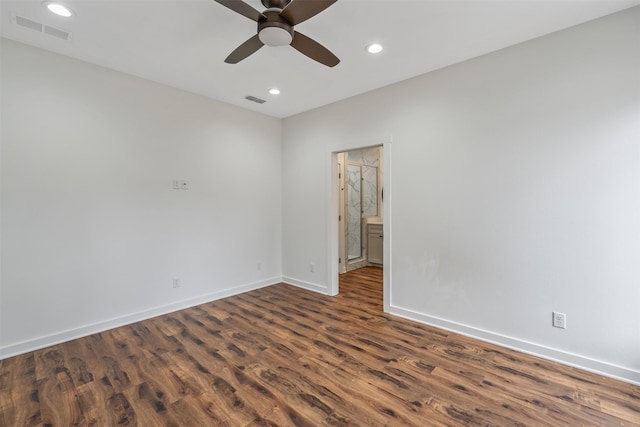 spare room with baseboards, visible vents, dark wood-style flooring, and recessed lighting