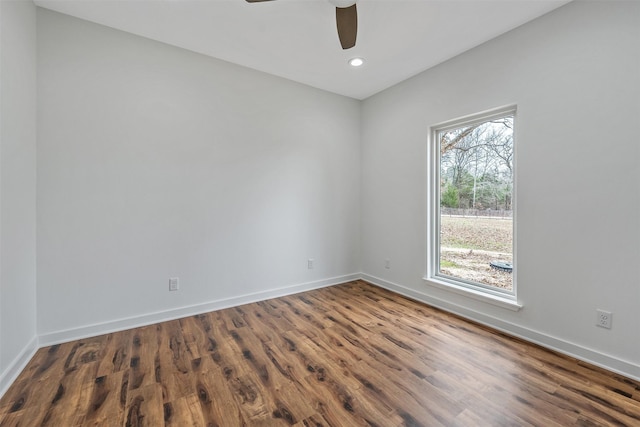 empty room with recessed lighting, wood finished floors, a ceiling fan, and baseboards