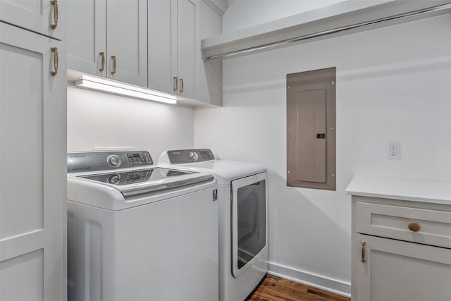 laundry area featuring dark wood-style flooring, washer and clothes dryer, cabinet space, electric panel, and baseboards