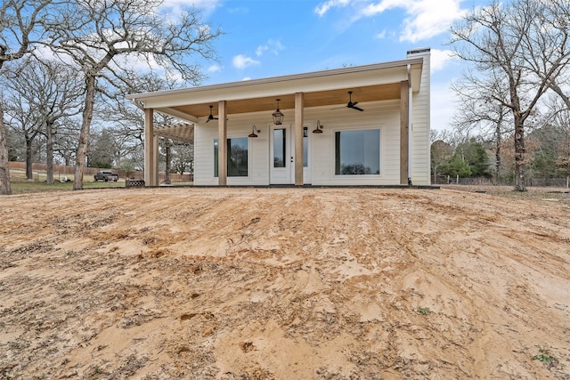 exterior space with a chimney and a ceiling fan