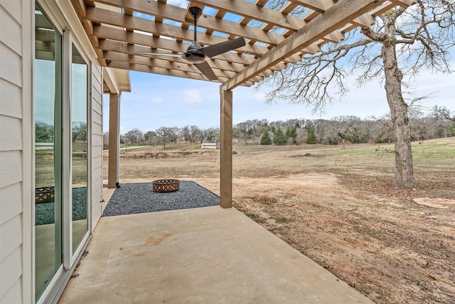 view of patio / terrace with an outdoor fire pit, a pergola, and a rural view