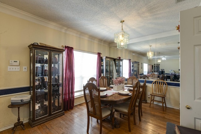 dining space with crown molding, a textured ceiling, and wood finished floors