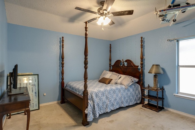 bedroom featuring light carpet, baseboards, a ceiling fan, and a textured ceiling