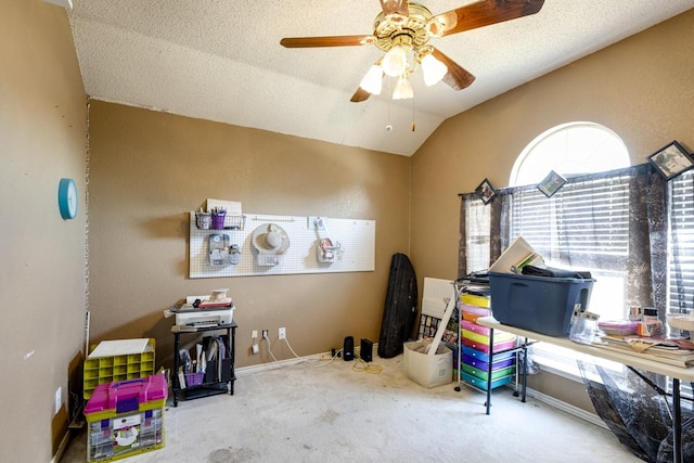 recreation room with lofted ceiling, a textured ceiling, carpet floors, a ceiling fan, and baseboards