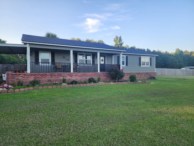 view of front facade with covered porch, fence, and a front yard