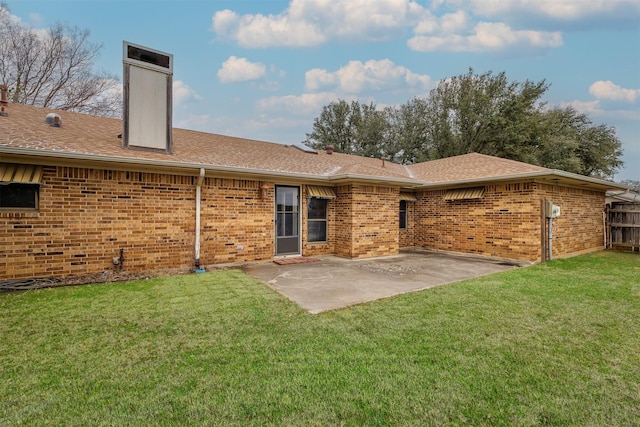 back of property with a patio area, brick siding, a lawn, and a chimney