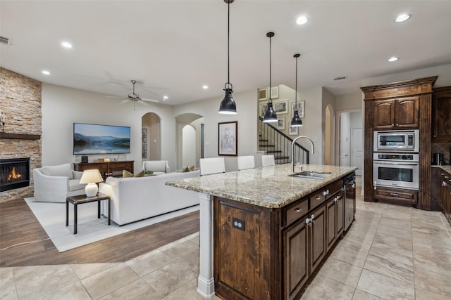 8 Center Ct, Heath, TX 75032 - kitchen with appliances with stainless steel finishes, recessed lighting, arched walkways, ceiling fan, and light stone counters