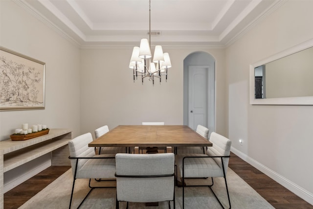 8 Center Ct, Heath, TX 75032 - dining room with a chandelier, a raised ceiling, wood finished floors, arched walkways, and crown molding