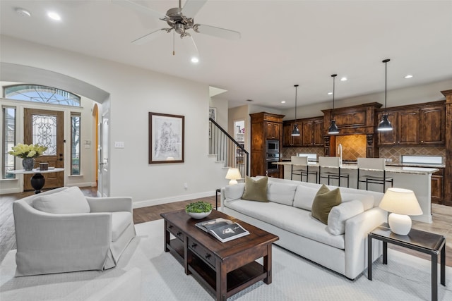 8 Center Ct, Heath, TX 75032 - living room featuring light wood-style flooring, ceiling fan, stairway, recessed lighting, and arched walkways