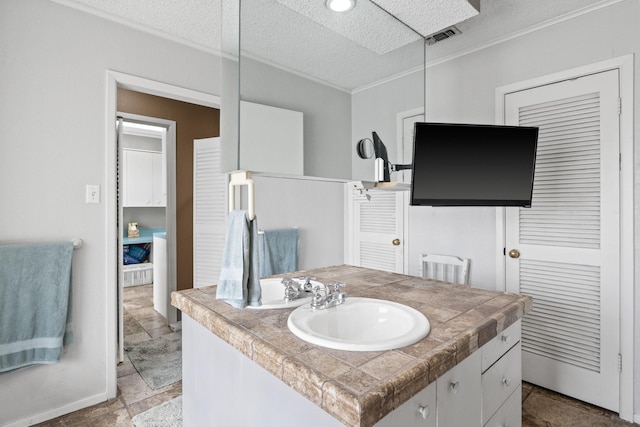 bathroom with visible vents, ornamental molding, stone finish floor, a textured ceiling, and vanity