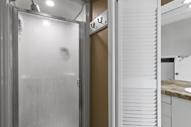 bathroom featuring a shower stall and vanity