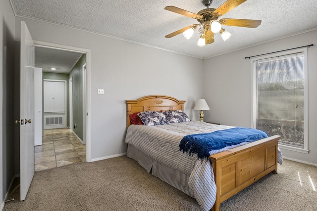 bedroom with ornamental molding, visible vents, light carpet, and a textured ceiling