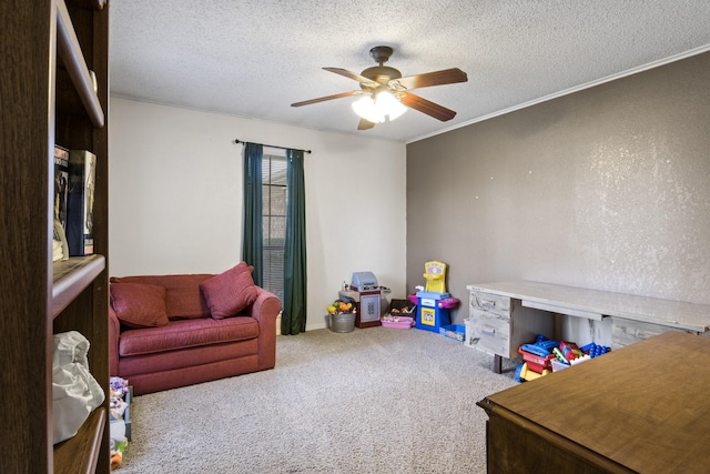 rec room featuring a textured ceiling, carpet, a ceiling fan, and crown molding