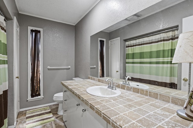 bathroom featuring a textured wall, toilet, ornamental molding, vanity, and baseboards