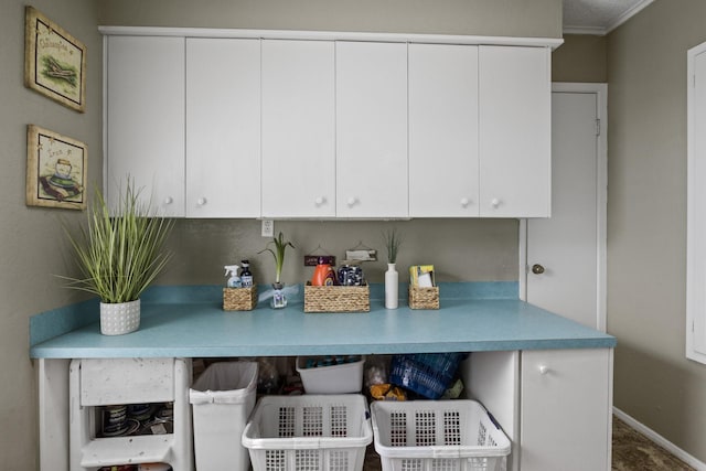 kitchen with light countertops, white cabinets, and baseboards