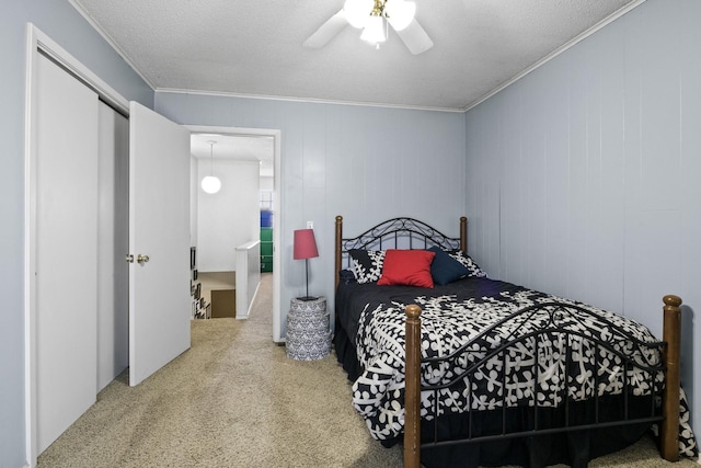 bedroom with a textured ceiling, carpet floors, ornamental molding, and ceiling fan