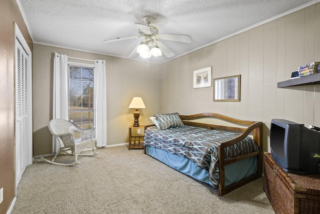 bedroom with carpet floors, a closet, crown molding, and a textured ceiling