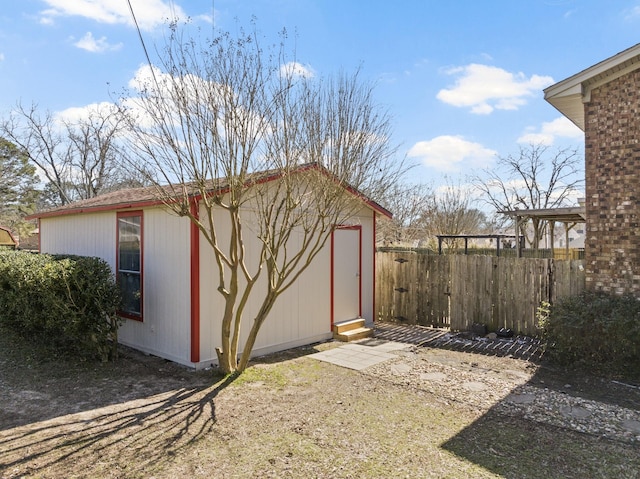 view of outdoor structure with an outbuilding and fence