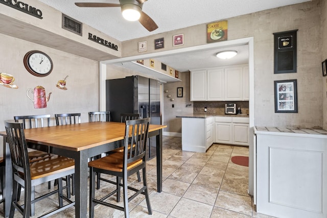 dining room with visible vents, ceiling fan, a textured ceiling, and light tile patterned floors