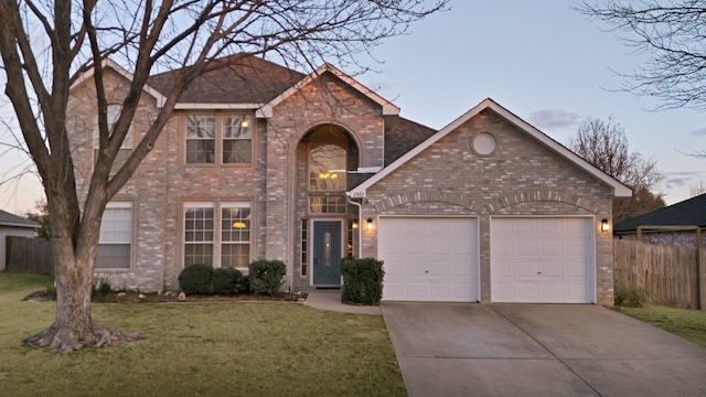 traditional home with a garage, brick siding, fence, concrete driveway, and a lawn