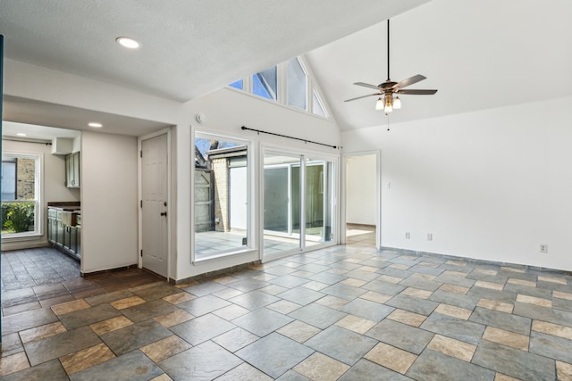 spare room with baseboards, ceiling fan, stone finish floor, high vaulted ceiling, and recessed lighting