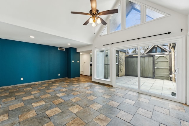 spare room with a ceiling fan, stone finish floor, visible vents, and high vaulted ceiling