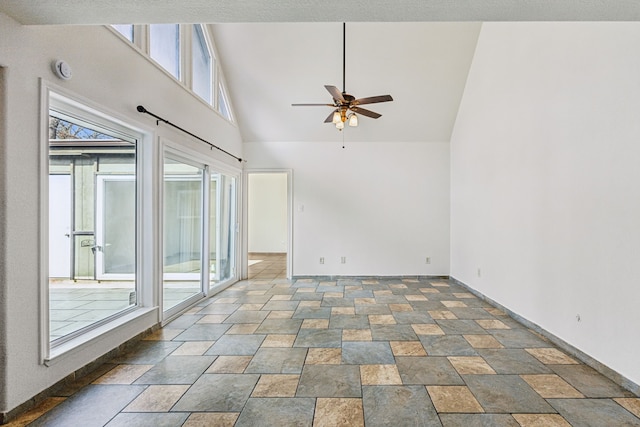 empty room with stone finish flooring, ceiling fan, and baseboards