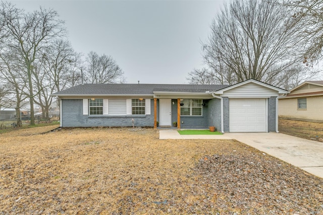 single story home featuring driveway, brick siding, a front lawn, and an attached garage