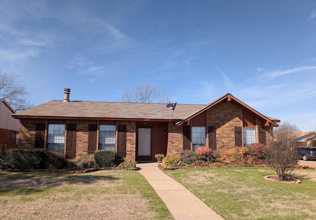 ranch-style home with brick siding and a front yard