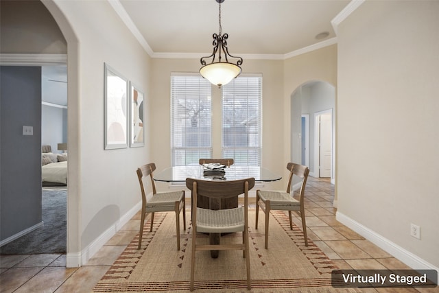 dining room with ornamental molding, arched walkways, and light tile patterned floors