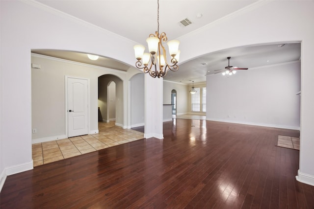 spare room featuring light wood-style floors, visible vents, arched walkways, and ornamental molding