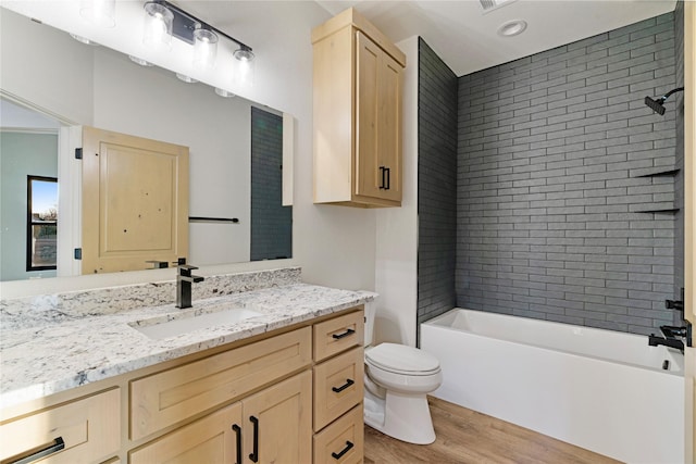 full bathroom with visible vents, toilet, shower / tub combination, wood finished floors, and vanity