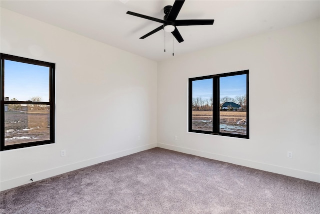 carpeted empty room with ceiling fan and baseboards