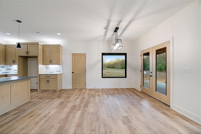 kitchen with visible vents, light wood-style flooring, decorative light fixtures, light brown cabinets, and backsplash