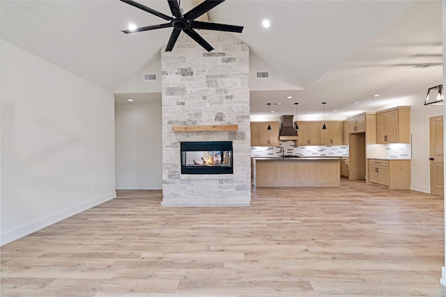 kitchen with hanging light fixtures, premium range hood, visible vents, and open floor plan