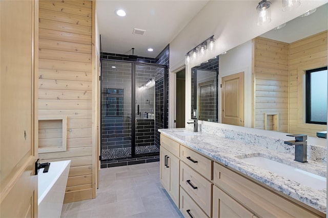 full bath with a sink, wood walls, a shower stall, and visible vents