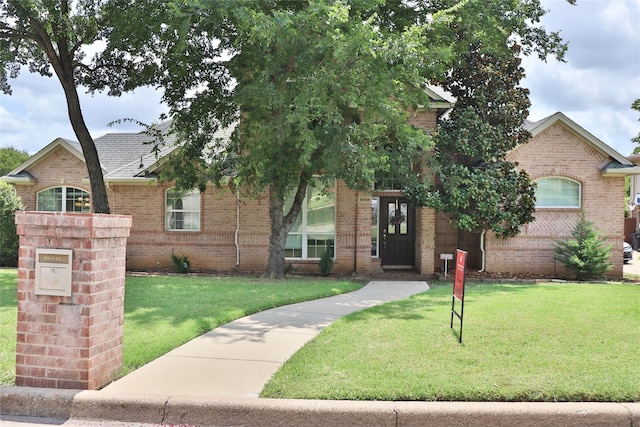 view of front of home with brick siding and a front lawn