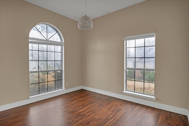 unfurnished room featuring dark wood-style floors and baseboards