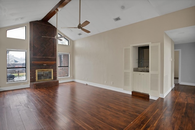 unfurnished living room featuring a wealth of natural light, visible vents, and dark wood finished floors