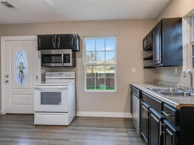 kitchen featuring light wood-style flooring, a sink, visible vents, light countertops, and appliances with stainless steel finishes