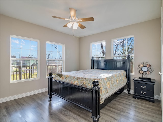 bedroom featuring ceiling fan, wood finished floors, and baseboards