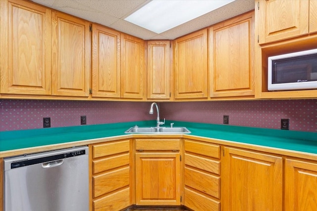 kitchen with dishwasher, light countertops, and a sink