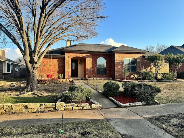 ranch-style house with brick siding and a chimney