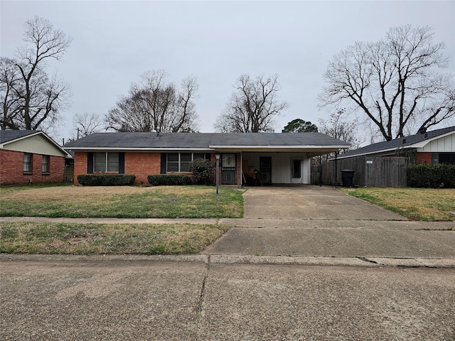 view of front of home featuring brick siding, concrete driveway, and a front yard