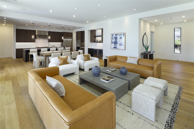 living room featuring recessed lighting, light wood-style flooring, and baseboards