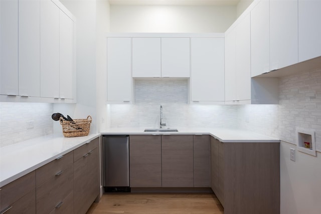 kitchen featuring light countertops, white cabinetry, a sink, and modern cabinets