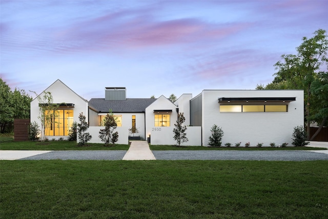 view of front of property with a yard and gravel driveway