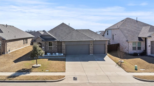 view of front facade with a garage, driveway, a shingled roof, fence, and brick siding