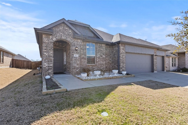 view of front facade with driveway, an attached garage, fence, a front lawn, and brick siding